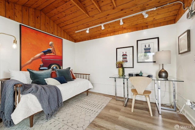 bedroom featuring rail lighting, wood finished floors, wooden ceiling, lofted ceiling, and baseboards