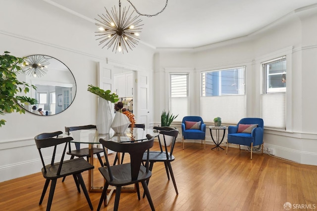 dining area with a chandelier, wood finished floors, and crown molding