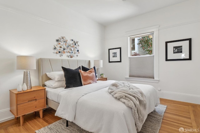 bedroom featuring light wood-style floors and baseboards