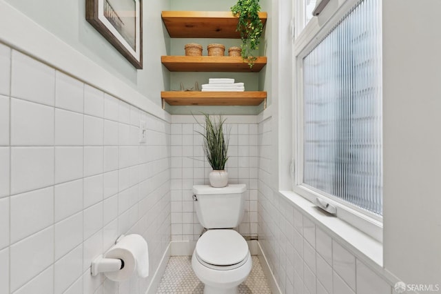 bathroom featuring tile walls, toilet, and tile patterned flooring