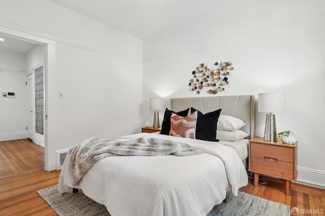 bedroom featuring wood finished floors and baseboards