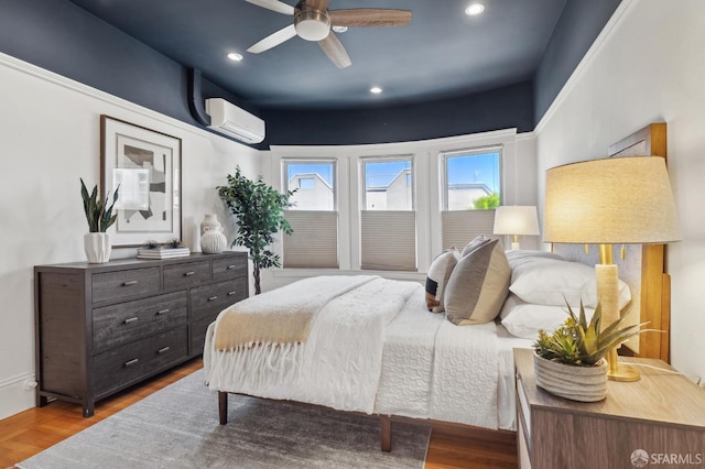 bedroom featuring a wall mounted AC, wood finished floors, recessed lighting, and ceiling fan