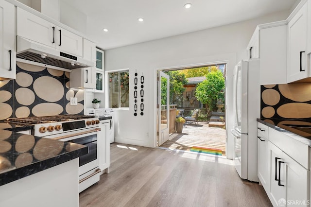kitchen with white appliances, under cabinet range hood, recessed lighting, light wood-style floors, and white cabinetry