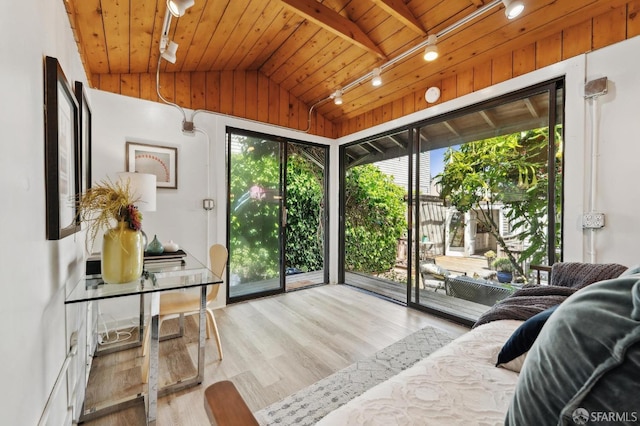 bedroom with access to exterior, lofted ceiling, wood ceiling, wood finished floors, and track lighting