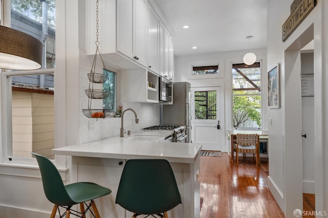 719-721 Shotwell St, San Francisco, CA 94110 - kitchen featuring stainless steel appliances, a sink, tasteful backsplash, white cabinets, and wood-type flooring