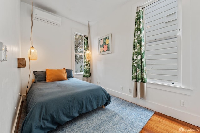 719-721 Shotwell St, San Francisco, CA 94110 - bedroom featuring an AC wall unit, wood finished floors, and baseboards
