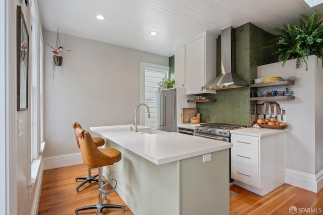 719-721 Shotwell St, San Francisco, CA 94110 - kitchen with wall chimney range hood, a sink, baseboards, backsplash, and light wood-style floors