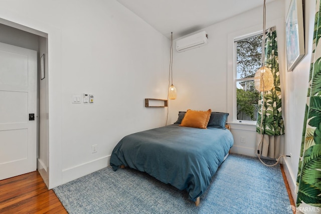 719-721 Shotwell St, San Francisco, CA 94110 - bedroom featuring a wall unit AC, wood finished floors, and baseboards