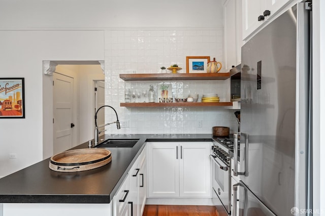 719-721 Shotwell St, San Francisco, CA 94110 - kitchen featuring appliances with stainless steel finishes, a sink, dark countertops, white cabinetry, and backsplash