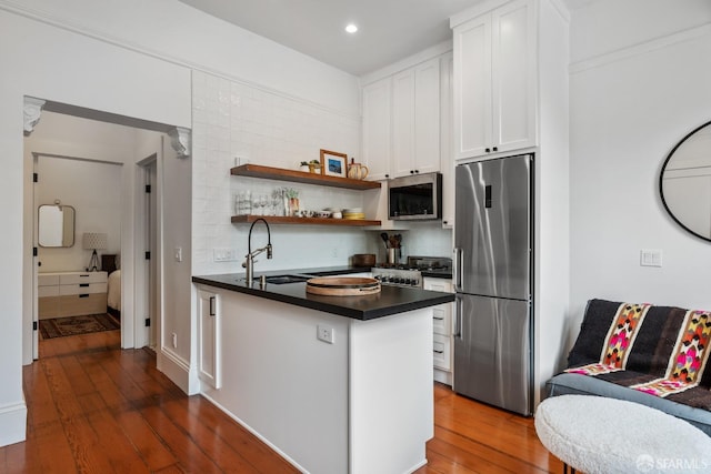 719-721 Shotwell St, San Francisco, CA 94110 - kitchen with stainless steel appliances, dark countertops, white cabinetry, dark wood-style flooring, and backsplash