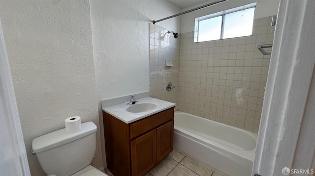 bathroom with vanity, washtub / shower combination, tile patterned floors, toilet, and a textured wall