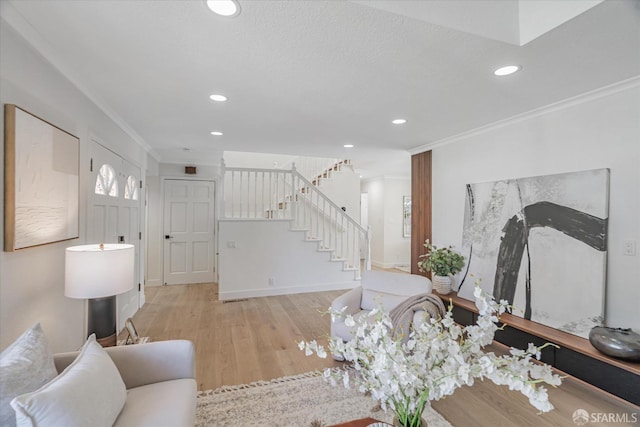 living room featuring stairway, recessed lighting, wood finished floors, and crown molding