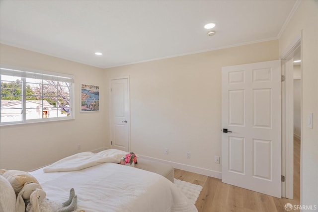 bedroom featuring ornamental molding, light wood finished floors, recessed lighting, and baseboards