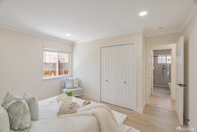 bedroom with ornamental molding, light wood finished floors, multiple windows, and a closet