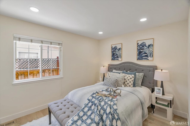 bedroom with recessed lighting, wood finished floors, visible vents, and baseboards