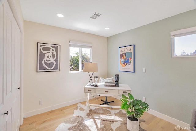 home office with light wood-style floors, baseboards, and visible vents