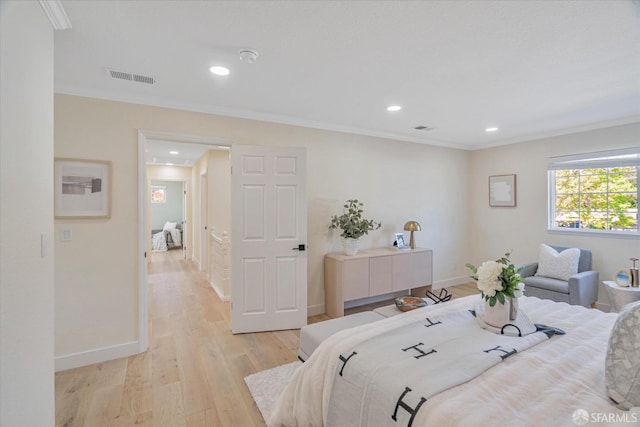 bedroom with baseboards, ornamental molding, visible vents, and light wood-style floors