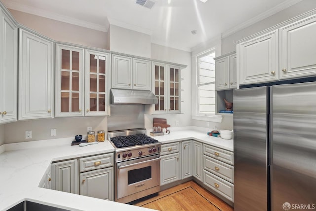 kitchen featuring crown molding, appliances with stainless steel finishes, under cabinet range hood, and visible vents