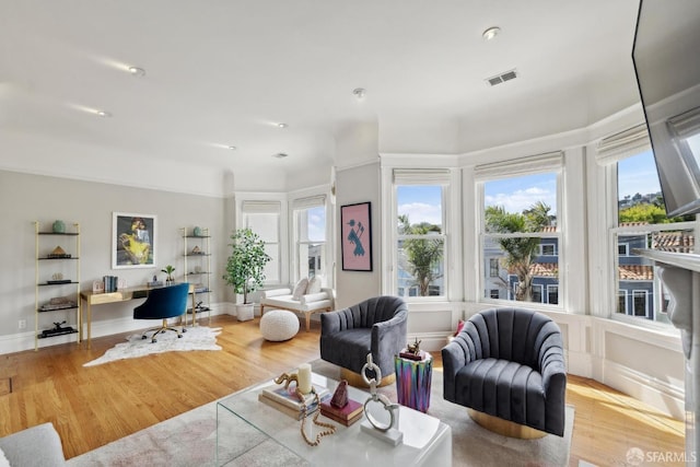 living area with visible vents and wood finished floors
