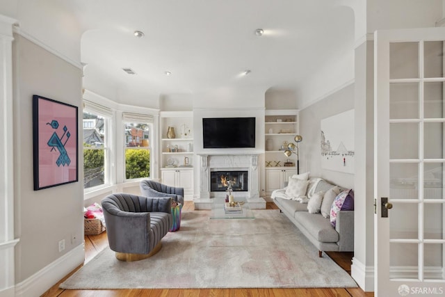 living area with baseboards, wood finished floors, and a premium fireplace