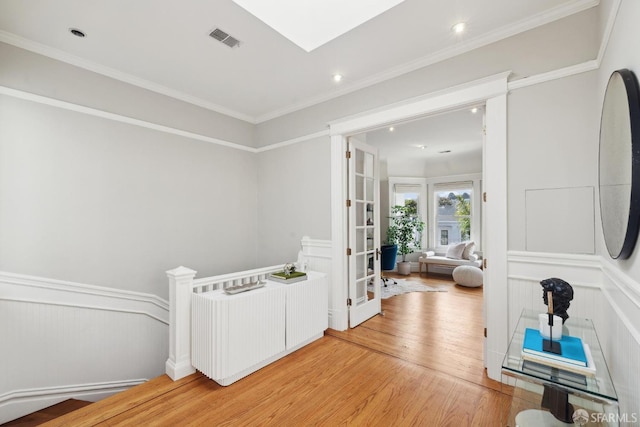 hallway featuring french doors, light wood-style flooring, recessed lighting, an upstairs landing, and visible vents