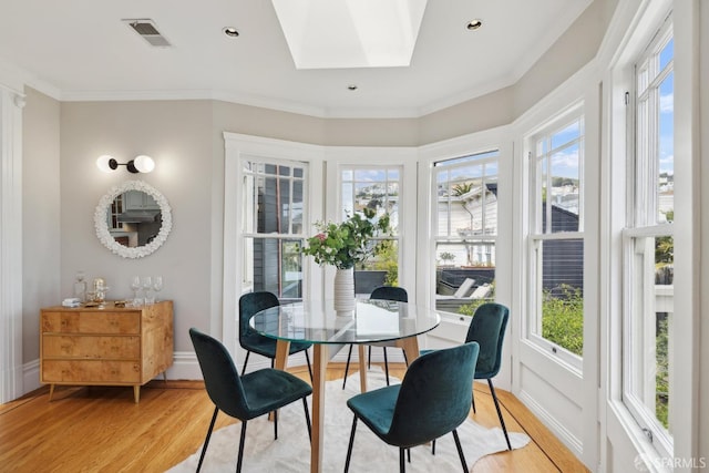 sunroom with a skylight, wood finished floors, and a wealth of natural light