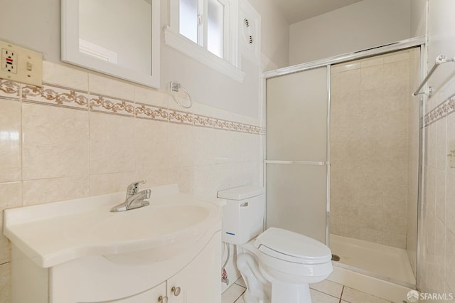 bathroom with a stall shower, tile walls, toilet, and tile patterned floors