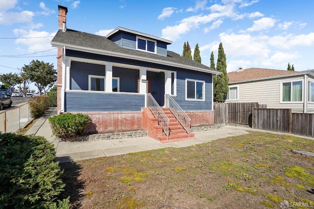 bungalow-style house with a porch and fence