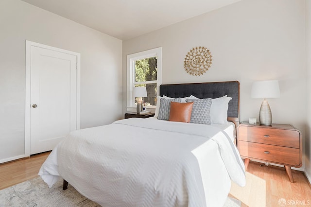 bedroom featuring baseboards and light wood finished floors