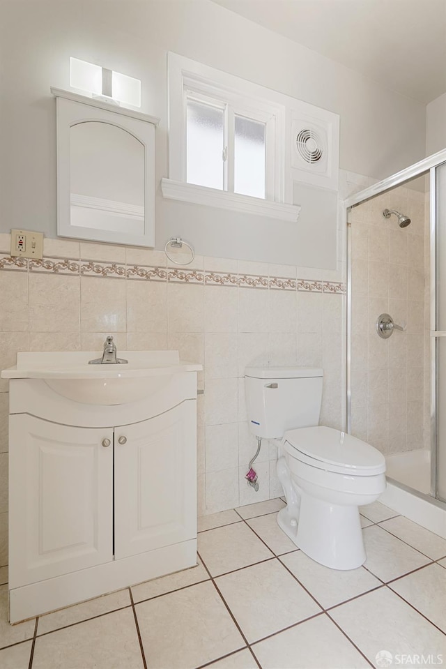 full bathroom with a stall shower, vanity, toilet, and tile patterned floors