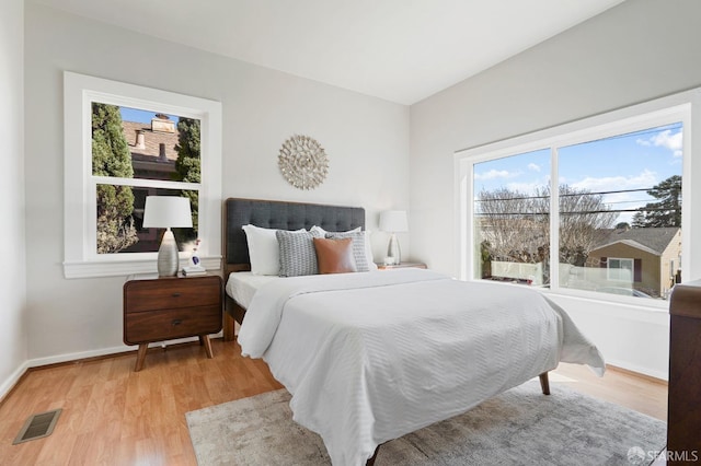 bedroom with light wood-style floors, baseboards, and visible vents