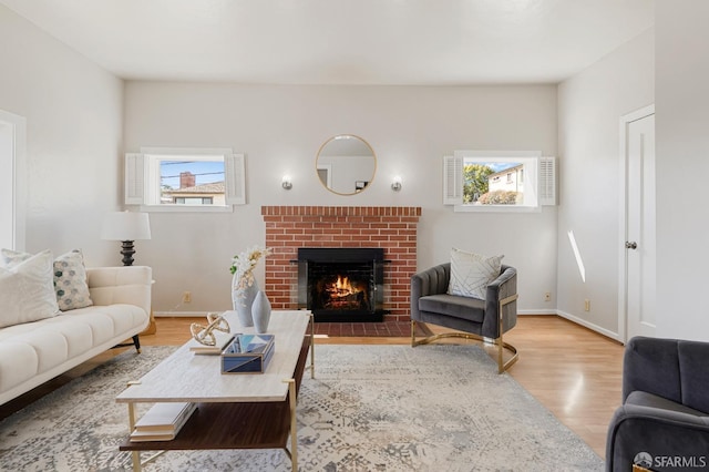 living room with a healthy amount of sunlight, a fireplace, baseboards, and wood finished floors