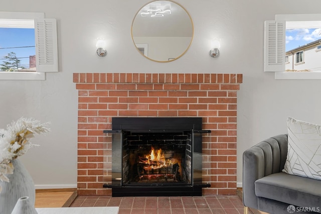 details featuring a brick fireplace, wood finished floors, and baseboards