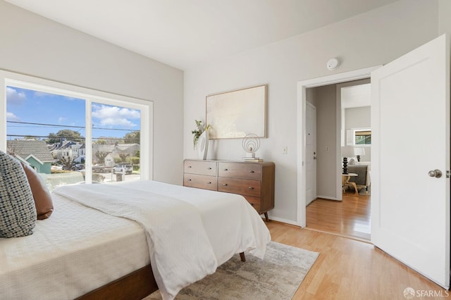 bedroom with light wood-type flooring and baseboards