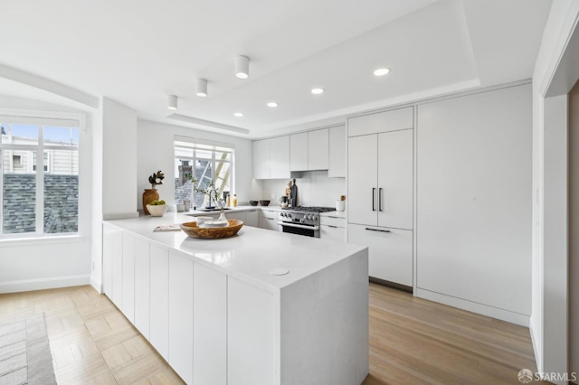 2100 Green St Unit 302, San Francisco, CA 94123 - kitchen featuring recessed lighting, light countertops, high end range, a peninsula, and modern cabinets