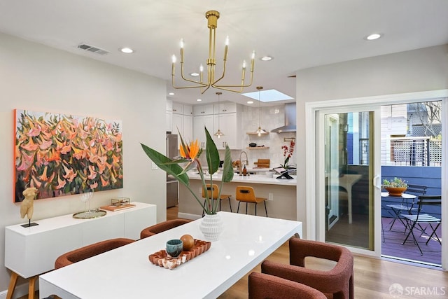 dining area featuring a notable chandelier, recessed lighting, wood finished floors, and visible vents