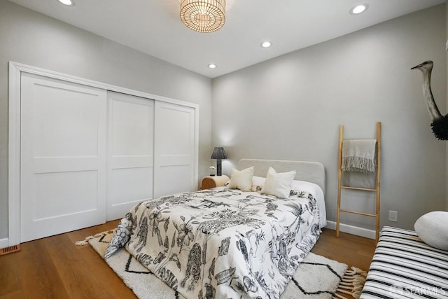 bedroom featuring a closet, recessed lighting, baseboards, and wood finished floors