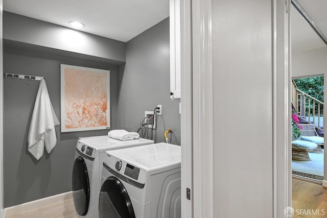 washroom featuring laundry area, baseboards, independent washer and dryer, and light wood-type flooring