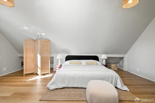 bedroom featuring wood finished floors and vaulted ceiling