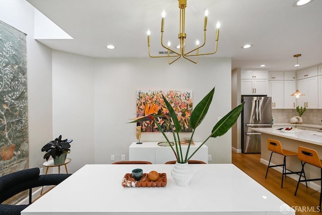 dining area featuring visible vents, recessed lighting, an inviting chandelier, and wood finished floors