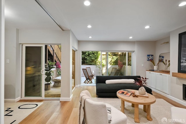 living room with recessed lighting, baseboards, and light wood-style floors