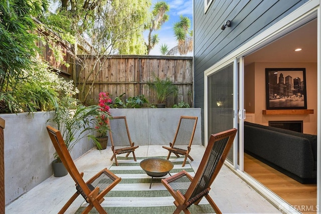 view of patio featuring an outdoor fire pit and fence