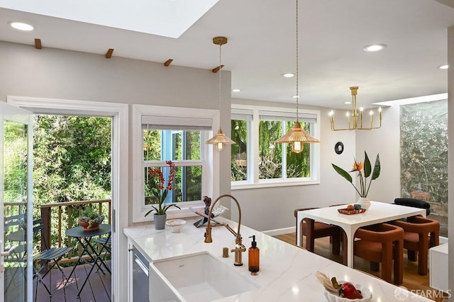 kitchen with light stone counters, recessed lighting, stainless steel dishwasher, and a sink