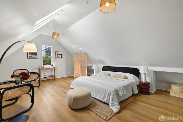 bedroom with lofted ceiling with skylight and wood finished floors