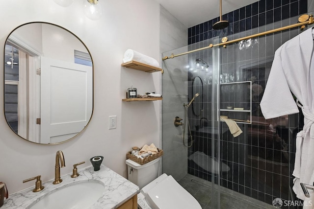 bathroom with a shower stall, vanity, and toilet