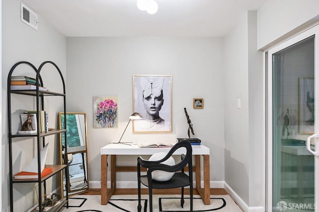 office area featuring light wood-style floors, baseboards, and visible vents