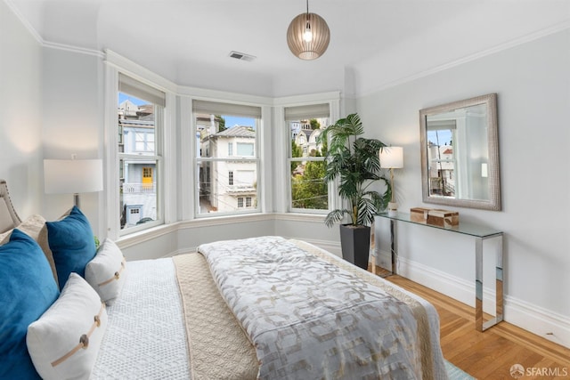 bedroom featuring hardwood / wood-style floors and crown molding