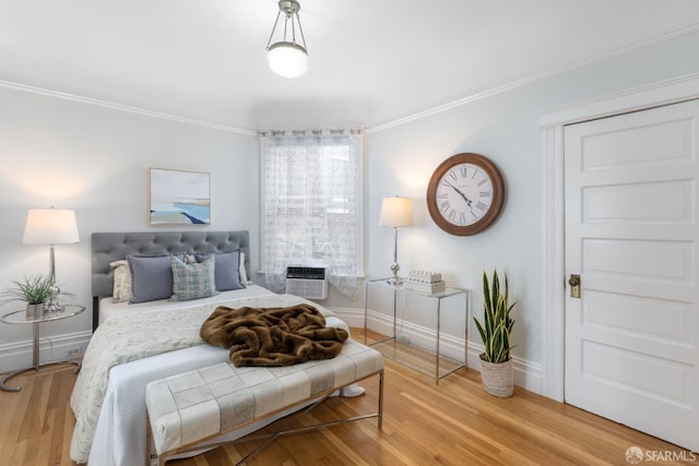 bedroom featuring ornamental molding, a wall mounted air conditioner, and hardwood / wood-style floors