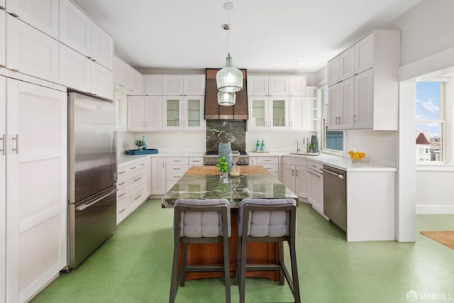 kitchen featuring a kitchen island, white cabinetry, appliances with stainless steel finishes, and a breakfast bar