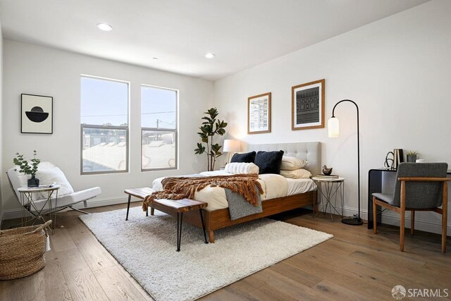 bedroom with baseboards, recessed lighting, and wood-type flooring